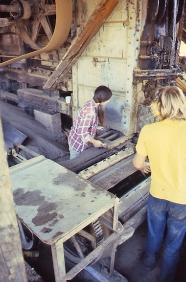 View of the worker putting an empty brick mold into the Martin press to be loaded. 
